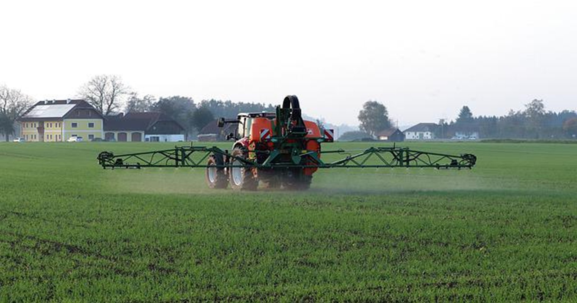 Pest control tractor spraying field.